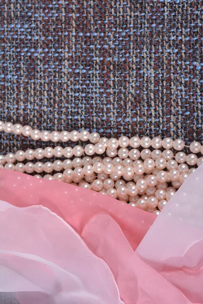 Abalorios hechos de perlas artificiales en el grosero hermoso tejido — Foto de Stock