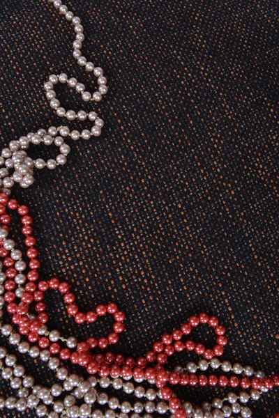 Perlen aus künstlichen Perlen auf dem unhöflich schönen Stoff. Hintergrund Eckrahmen — Stockfoto