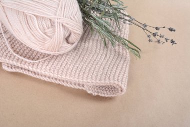 Örme, bej bir eşarp ve bir demet kurutulmuş lavanta için yün iplik bobin