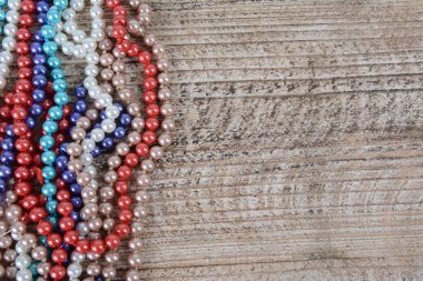 Dokulu ahşap arka planda renkli boncuk çerçevesi