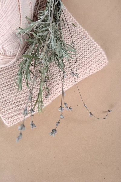 Bobina de fios de lã para tricotar, um lenço bege e um monte de lavanda seca — Fotografia de Stock