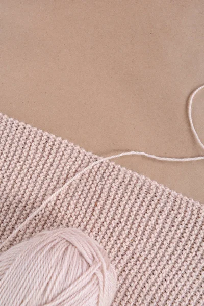 Una matassa di lana e una sciarpa lavorata a maglia di filo beige . — Foto Stock