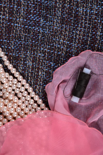 Perlenkette und sanft rosa Stoff auf dem grauen Hintergrund — Stockfoto