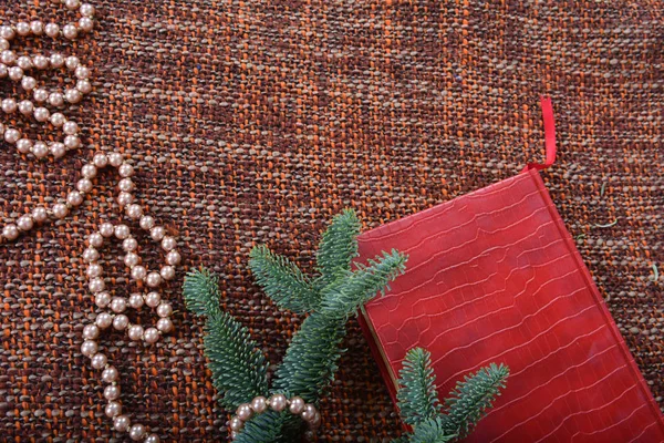 Weihnachtsdekoration mit Perlen, Perlen, Tannenzweigen und rotem Buch. — Stockfoto