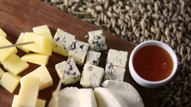 Un plato de queso. Tablero de madera con varios tipos de queso y miel . — Vídeos de Stock