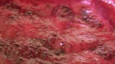 Bir tencerede kaynamış siyah frenk üzümü reçeli. Yakın plan.