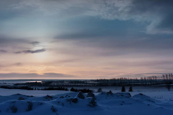 背景に雪のバンプと川のあるフィールドで冬の日の出 — ストック写真