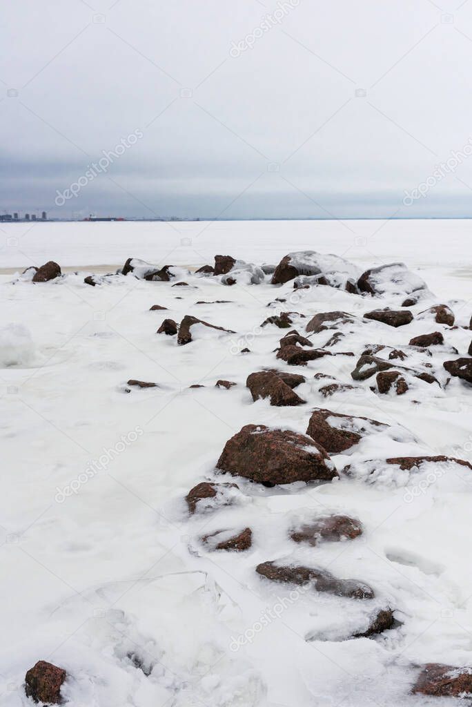 Stone breakwater frozen into the sea