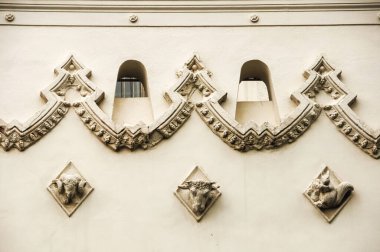 Pencereleri ve rampaları koç, boğa ve sincap şeklinde olan dekoratif bir duvar.