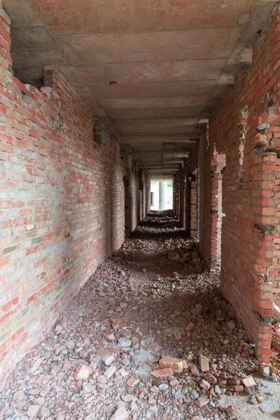 Corridor of a destroyed old hotel with broken doors and damaged floor