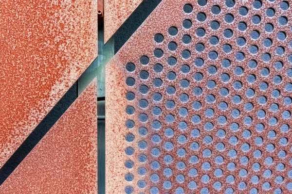 錆びた穿孔金属クラッディングプレートを持つ抽象幾何学的背景 — ストック写真