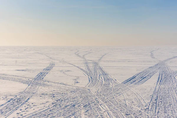 冬の凍った雪に覆われた湖でスノーモービルが走る — ストック写真