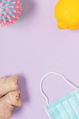 Koronavirüs temalı düz uzanma: yüz maskesi, limon ve zencefil kökü