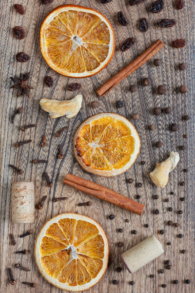 Ingredients for mulled wine on wooden background. Dried orange, cinnamon sticks, black pepper, cloves, dried ginger, wine cork. Top view, flat lay, copy space.