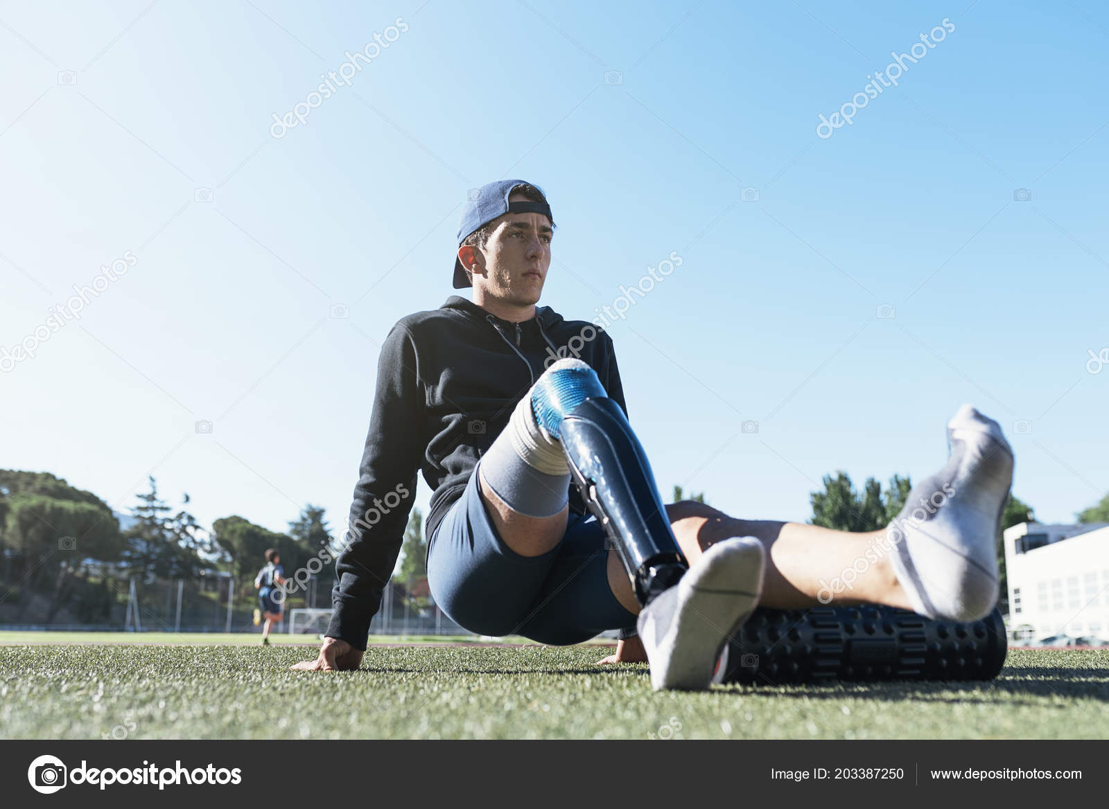 Garota esportiva em leggins azuis usando celular durante exercícios  matinais ao ar livre no campo esportivo