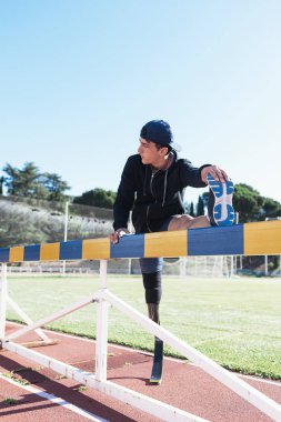 Engelli adam atlet bacak protezi ile germe. Paralimpik spor kavramı.