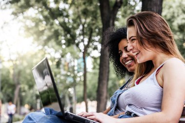 Güzel kadınlar sokakta bir dizüstü bilgisayar kullanarak. Gençlik kavramı.