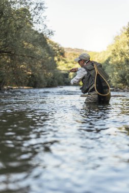 Sinek balıkçı güzel nehirde flyfishing çubuk kullanarak