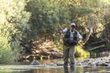 Sinek balıkçı güzel nehirde flyfishing çubuk kullanarak