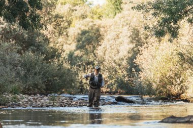 Sinek balıkçı güzel nehirde flyfishing çubuk kullanarak