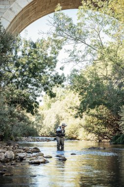 Sinek balıkçı güzel nehirde flyfishing çubuk kullanarak