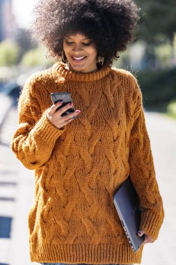 Cep telefonuyla sokakta çekici afro kadın portresi. İş kadın kavramı