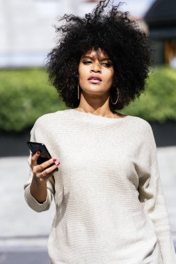 Cep telefonuyla sokakta çekici afro kadın portresi. İş kadın kavramı