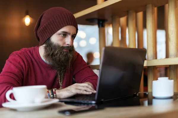 Dizüstü Bilgisayarda Yazarken Kahve Sahip Kafede Oturan Örgülü Sakallı Yetişkin — Stok fotoğraf