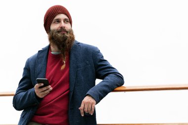 Yakışıklı trendy hipster smartphone kullanarak kapalı şapka ve mavi ceketli