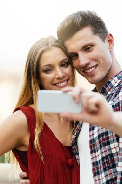 Romantik Genç çift cep telefonu ile fotoğraf çekme. İlişki kavramı