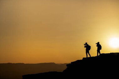 Bir gün batımı dağda vuruyor silüeti tanınmayan bir fotoğrafçı. Fotoğrafçı kavramı