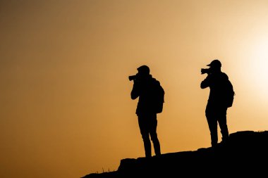 Bir gün batımı dağda vuruyor silüeti tanınmayan bir fotoğrafçı. Fotoğrafçı kavramı