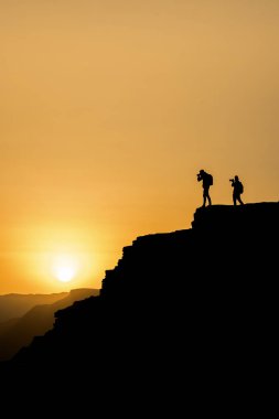 Bir gün batımı dağda vuruyor silüeti tanınmayan bir fotoğrafçı. Fotoğrafçı kavramı