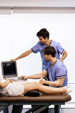 Physiotherapist giving knee therapy to a woman clipart