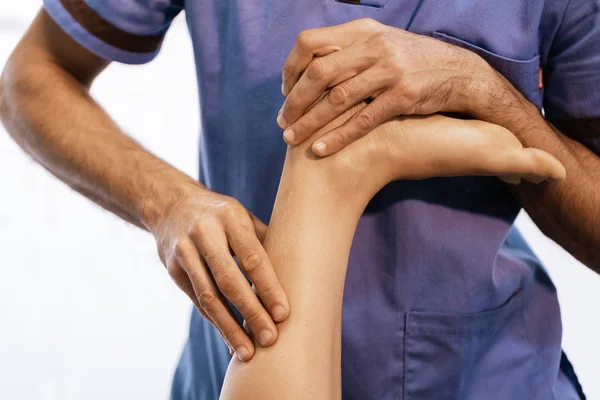 Fisioterapeuta dando terapia de rodilla a una mujer — Foto de Stock