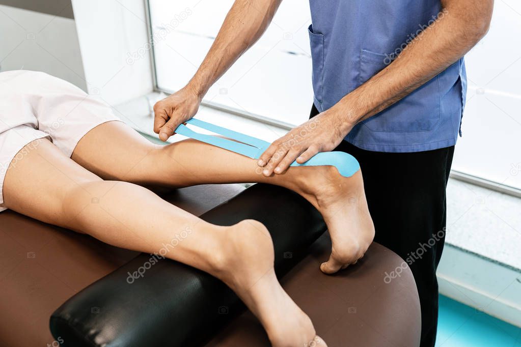 Physiotherapist giving calf therapy to a woman