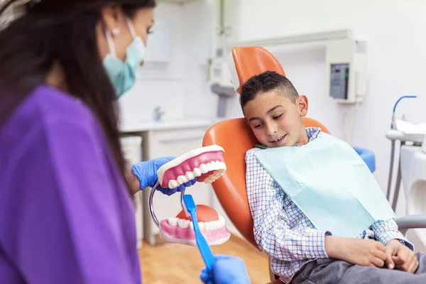 Γιατρός οδοντίατρος διδασκαλία ένα παιδί να βουρτσίζετε τα δόντια. — Φωτογραφία Αρχείου