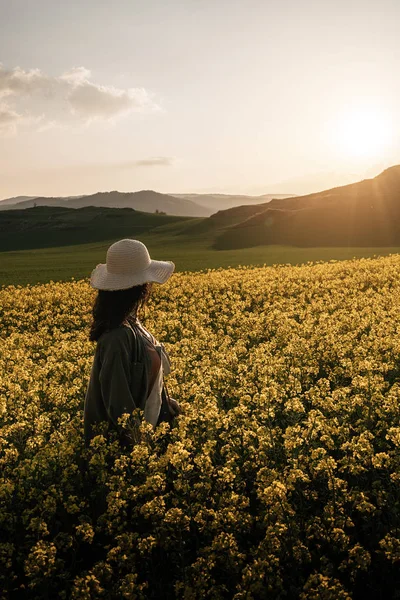 Onherkenbaar vrouw wandelen tussen bloemen — Stockfoto