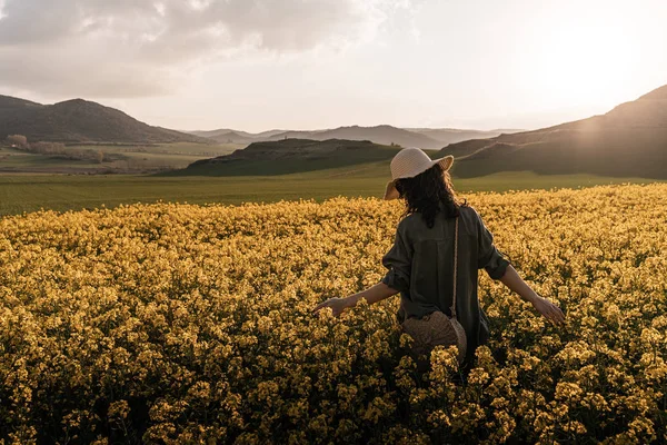 Onherkenbaar vrouw wandelen tussen bloemen — Stockfoto