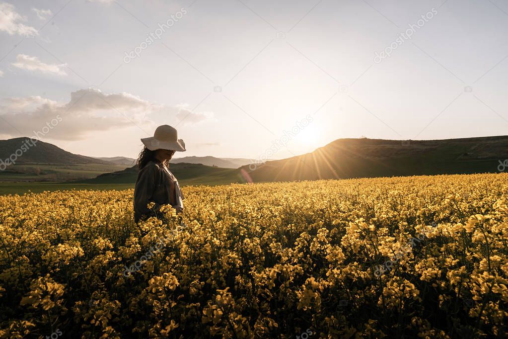 Unrecognizable woman walking among flowers