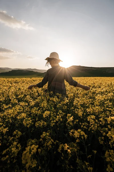 Nerozpoznatelná žena, která kráčí mezi květinami — Stock fotografie