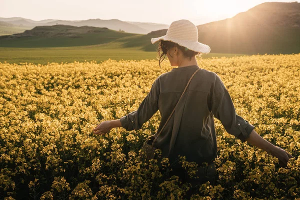 Unrecognizable woman walking among flowers