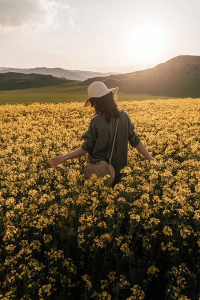 Onherkenbaar vrouw wandelen tussen bloemen — Stockfoto