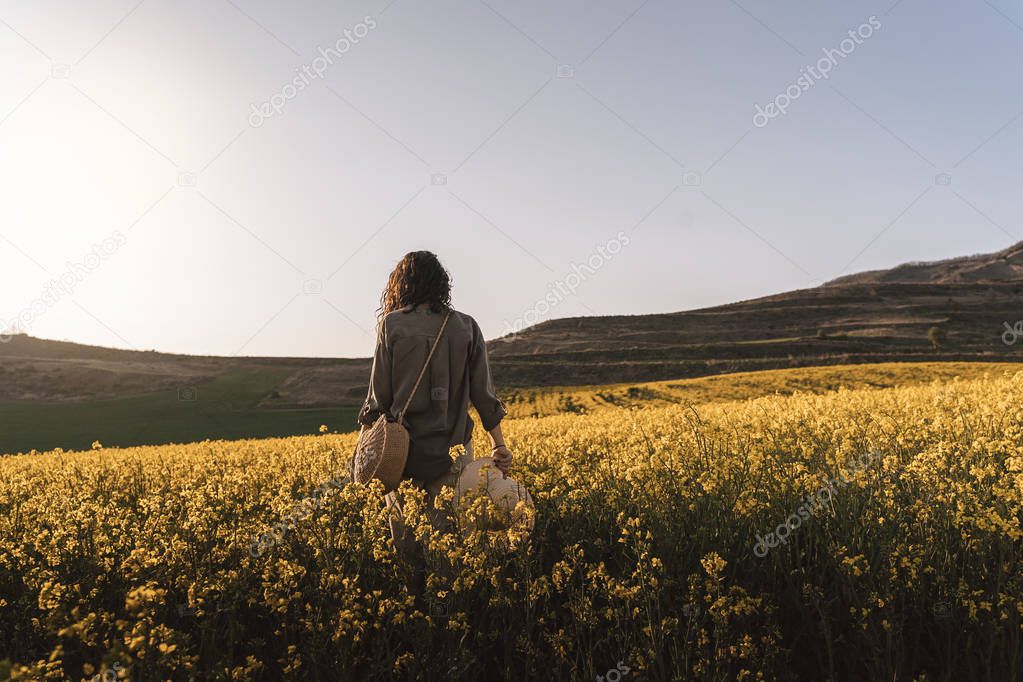 Unrecognizable woman walking among flowers