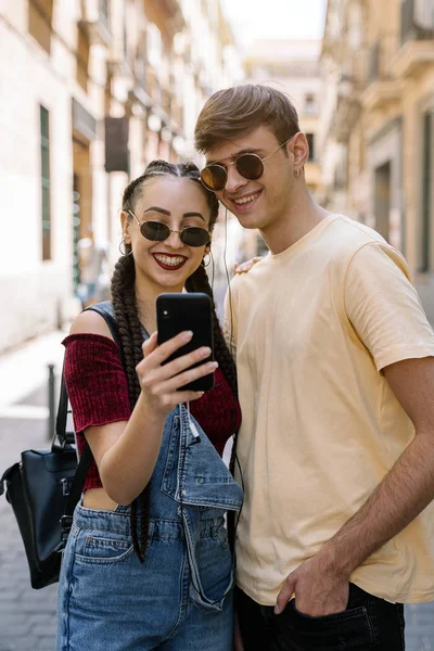 Feliz joven pareja usando el teléfono móvil — Foto de Stock