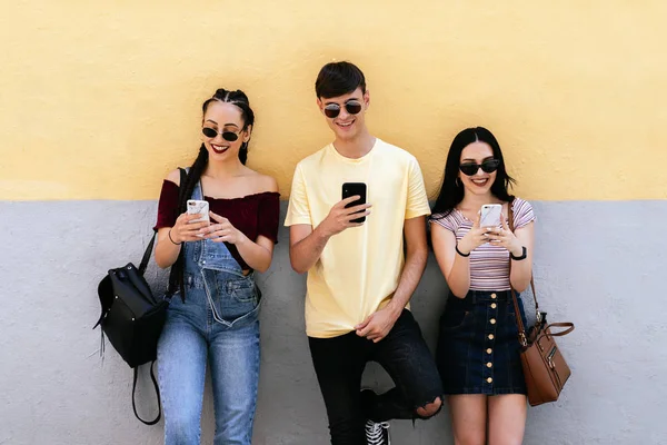 Grupo de jóvenes amigos usando el teléfono móvil — Foto de Stock