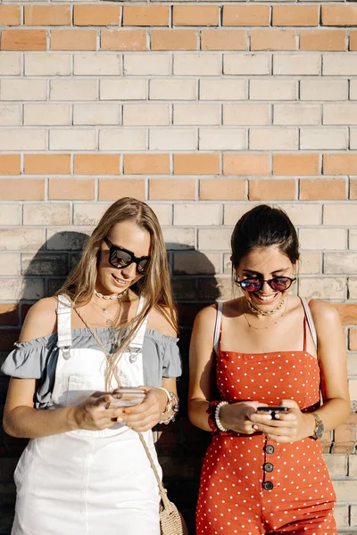 Atractivas jóvenes turistas utilizando teléfonos celulares fuera — Foto de Stock