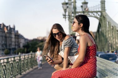 Köprüde birbirleriyle iletişimin keyfini çıkaran genç kadınlar