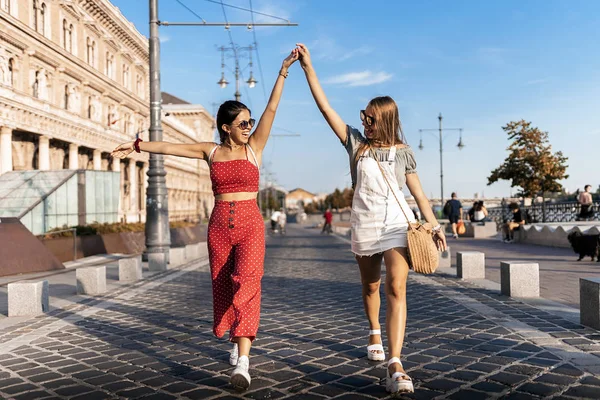 Attractive young women enjoying travelling along city — Stock Photo, Image