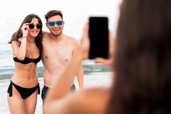 Жінка фотографує пару після плавання на пляжі — стокове фото